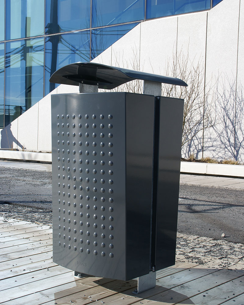 Stylish steel litterbin outside a glass office building.